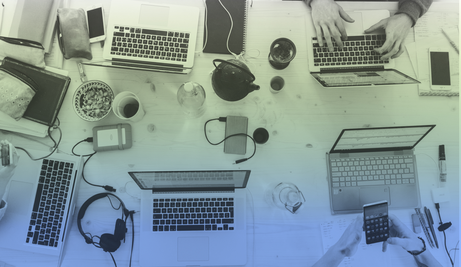 people typing on laptops, tea pots, coffee cups